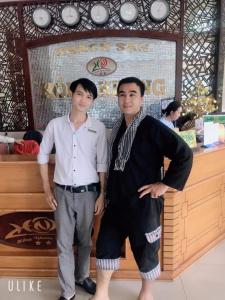 two men are standing in front of a store at Hồng Nhung Hotel Kiên Giang in Rach Gia