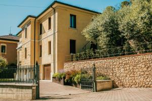 un edificio con una valla junto a una pared de piedra en Naboo Verona Luxury Suites en Verona