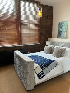 a bedroom with a large bed in a room with windows at Unique Cathedral Quarter Victorian Apartment in Sheffield