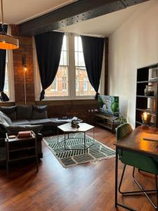 a living room with a couch and a table at Unique Cathedral Quarter Victorian Apartment in Sheffield