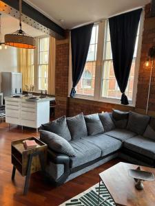 uma sala de estar com um sofá e uma mesa em Unique Cathedral Quarter Victorian Apartment em Sheffield