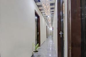 a hallway with a plant and lights on the ceiling at OYO Flagship 87416 Hotel Moonstar in Ghaziabad
