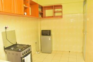 a kitchen with a stove and a refrigerator at The O,S Homestay in Chuka