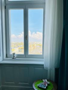 Danube Panorama apartments في بودابست: نافذة مع دمية الدب يجلس على طاولة في الأمام