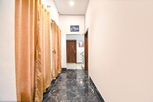 a hallway with orange curtains and a black tile floor at FabExpress Golden Stays in Kolkata