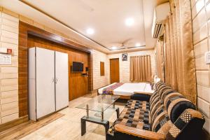 a room with a bed and a couch and a bedroom at FabExpress Golden Stays in Kolkata