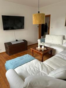 a living room with two white couches and a table at Wunderschöne Altbauwohnung in Bremerhaven