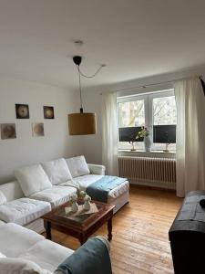 a living room with two white couches and a table at Wunderschöne Altbauwohnung in Bremerhaven