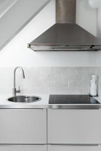 a kitchen with white cabinets and a sink at North Sea's White Shelter - 4 personnes in Koksijde