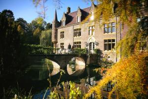 un edificio con un puente sobre un río en Van der Valk Hotel Kasteel Terworm en Heerlen