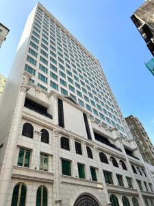 un alto edificio bianco con molte finestre di Kew Green Hotel Mongkok a Hong Kong