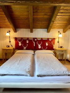 a large bed with a red headboard in a bedroom at Appartamento Emanuel in Livigno