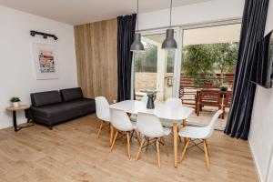 ein Wohnzimmer mit einem weißen Tisch und Stühlen in der Unterkunft Olive Tree Apartments 2 in Vodice