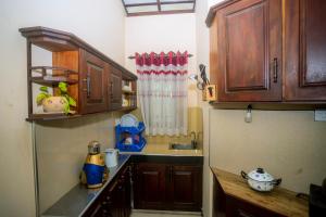 a kitchen with wooden cabinets and a sink at Sajini Villa in Weligama