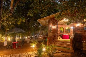 a small house with lights in a yard at night at Dandeli Jungle Stay in Dandeli