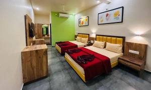 two beds in a room with green and white at Dandeli Jungle Stay in Dandeli