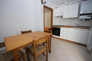 eine kleine Küche mit einem Holztisch und Stühlen in der Unterkunft 67 Bellaria Bilocale vicino al mare in Bellaria-Igea Marina