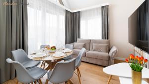 a living room with a table and chairs and a couch at Wonder Home - Domki Hillside tuż przy stoku narciarskim - na terenie kompleksu plac zabaw i zewnętrzna siłownia in Karpacz