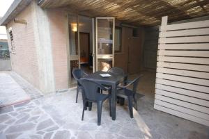 einen schwarzen Tisch und Stühle auf einer Terrasse in der Unterkunft 67 Bellaria Bilocale vicino al mare in Bellaria-Igea Marina
