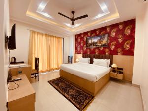 um quarto com uma cama grande e uma parede vermelha em Hotel DSR Corporate Suite Sector 45 Gurgaon em Gurgaon