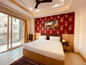 a bedroom with a large bed with a red wall at Hotel DSR Corporate Suite Sector 45 Gurgaon in Gurgaon