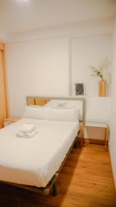 1 cama con sábanas blancas y almohadas en una habitación en APARTMENTS LA LONJA DE LA SEDA, en Valencia