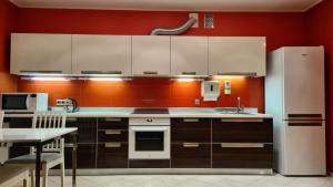 a kitchen with brown cabinets and a white refrigerator at Gudeliu in Vilnius