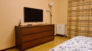 een slaapkamer met een dressoir en een televisie bij Gudeliu in Vilnius