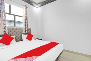 a bedroom with a bed with red pillows and a window at OYO Flagship 87416 Hotel Moonstar in Ghaziabad