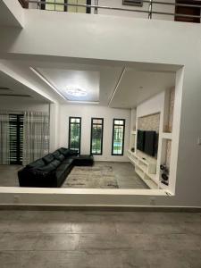 Rufisque的住宿－Villa Eve，客厅配有黑色沙发和平面电视。