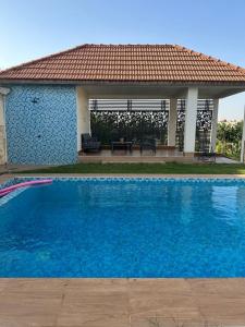 a large blue swimming pool in front of a house at Villa Eve in Rufisque