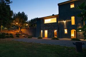 een groot bakstenen huis met lichten aan bij Rara Factory Design House in Orvieto