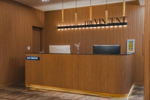 a lobby with a reception desk with a sign on the wall at JEONJU HOTEL THE VINCENT in Jeonju