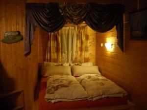 ein kleines Bett in einem Zimmer mit Fenster in der Unterkunft Chalet Hansl in Vordernberg