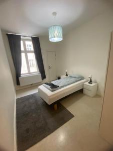 een witte slaapkamer met een bed en een raam bij Elegant Apartment In The City in Göteborg