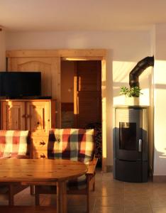 a living room with a wooden table and a kitchen at Parton Villa Apartments in Fonyód