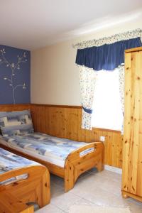 two beds in a room with a window at Parton Villa Apartments in Fonyód