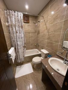 a bathroom with a toilet and a sink and a tub at King Of Pyramids Hotel in Cairo