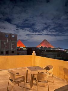 a patio with a table and chairs on a roof at King Of Pyramids Hotel in Cairo