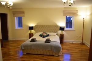 a bedroom with a large bed and two windows at Spacious County Durham Home in Durham