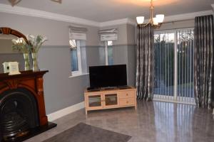 sala de estar con TV de pantalla plana sobre una mesa en Spacious County Durham Home en Durham