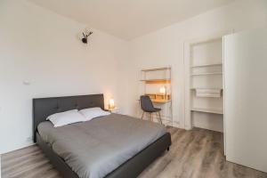 um quarto com uma cama, uma secretária e uma cadeira em Appartement au cœur de Saint-Brieuc em Saint-Brieuc