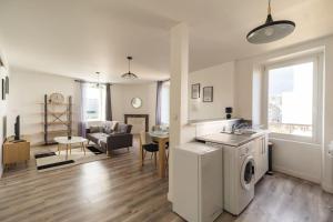 uma cozinha e sala de estar com máquina de lavar e secar roupa em Appartement au cœur de Saint-Brieuc em Saint-Brieuc