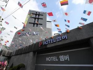 a hotel sign on top of a building with flags at Hotel Travel in Incheon