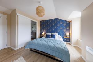 Carladez - 3 chambres et vue montagne في Vezac: غرفة نوم بحائط ذات لهجة زرقاء وسرير