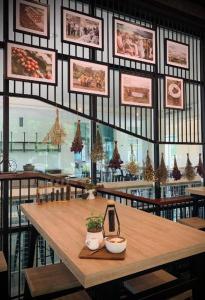 Valaya Hotel Pathumthani في Ban Lam Rua Taek: طاولة في مطعم مع زينة عيد الميلاد على الحائط