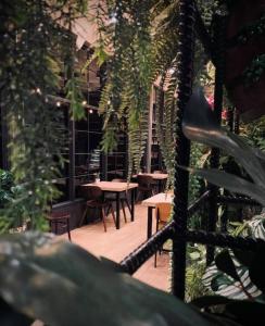 Valaya Hotel Pathumthani في Ban Lam Rua Taek: فناء في الهواء الطلق مع طاولات وكراسي ونباتات