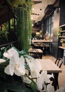 un gruppo di fiori bianchi seduti accanto a un tavolo di Valaya Hotel Pathumthani a Ban Lam Rua Taek