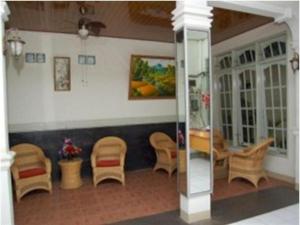 una camera con un gruppo di sedie e un tavolo di Hotel Bintang a Kampungdurian