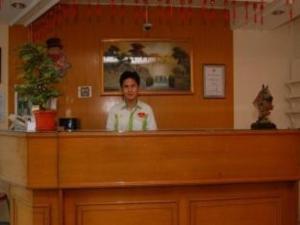 a woman standing behind a counter in a restaurant at Hotel Bintang in Kampungdurian